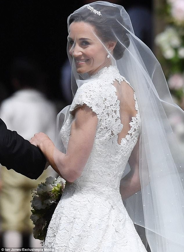 In questa foto Pippa Middleton prima di entrare in chiesa nel giorno del suo matrimonio si gira indietro sorridendo e tenendosi al braccio del padre