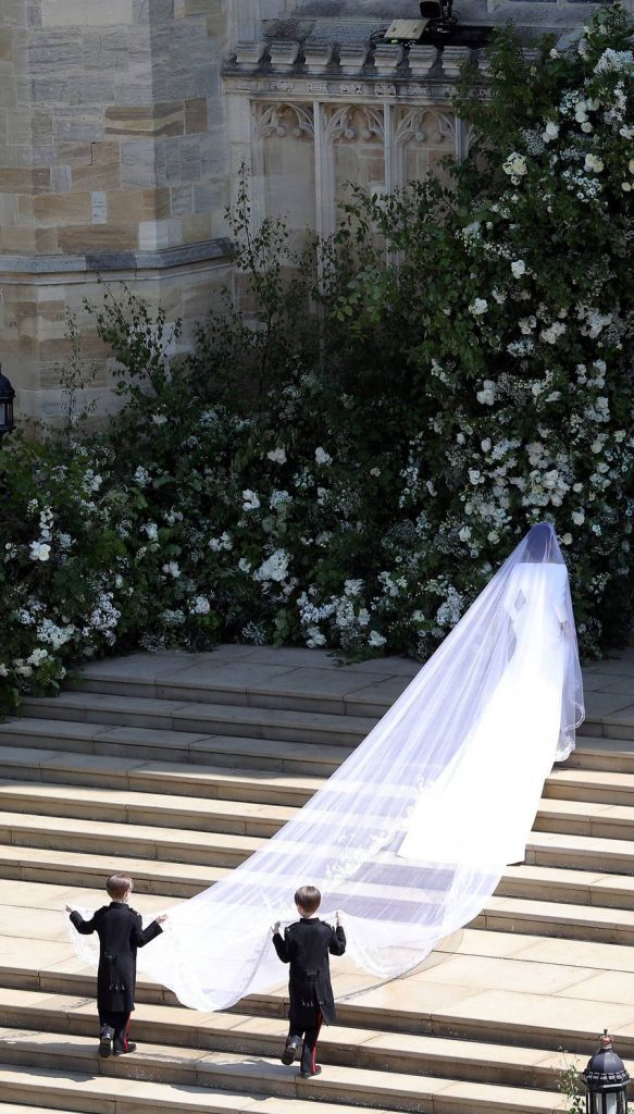 In questa Meghan Markle nel giorno del suo matrimonio sulle scale del sagrato della  cappella di San Giorgio nel Castello di Windsor. Indossa un velo da sposa Royal sorretto da due paggetti 