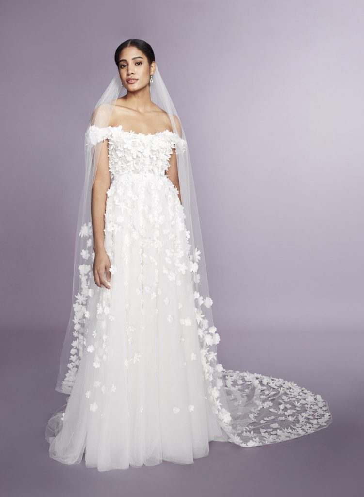 In questa foto una modella possa indossando un abito e un velo con fiori 3D firmato Marchesa Notte Bridal
