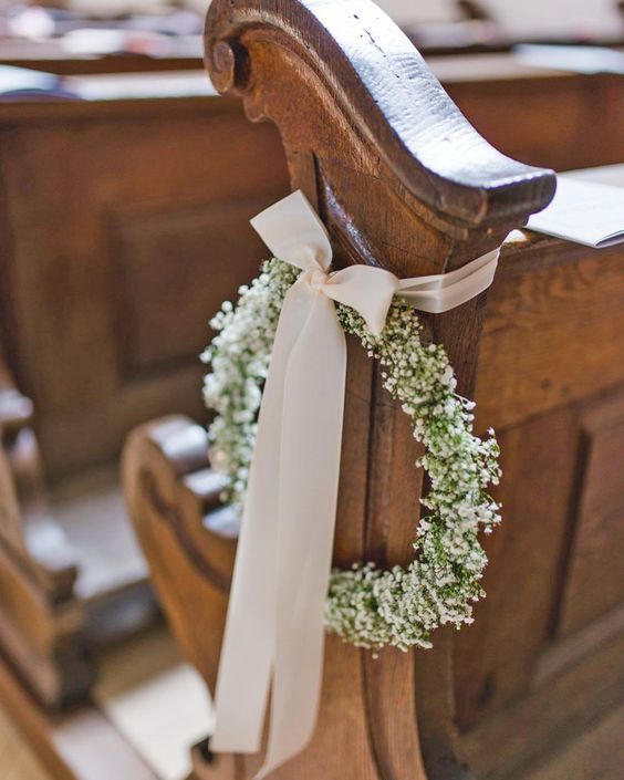 In questa foto il dettaglio di una decorazione per un matrimonio in chiesa. È un cerchio di nebbiolina legato con un nastro rosa cipria chiuso a fiocco