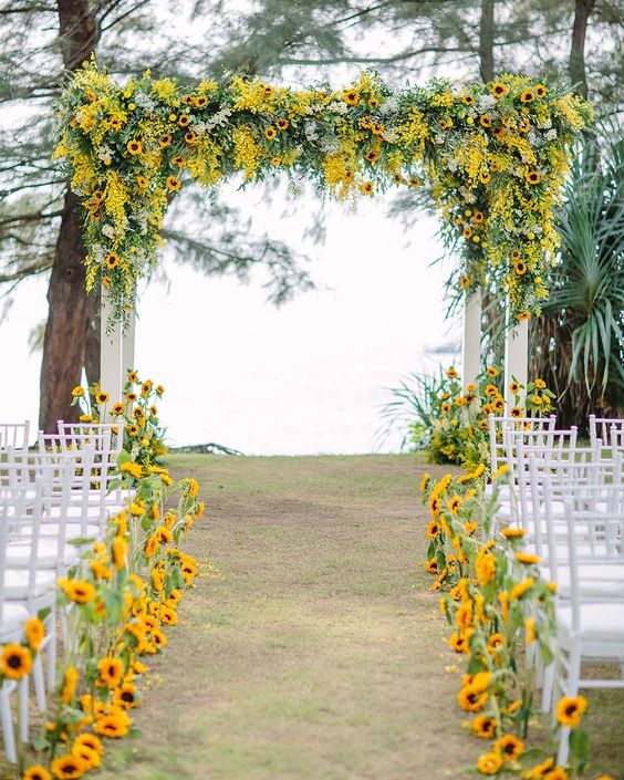 In questa foto l'allestimento di un matrimonio civile con girasoli sul gazebo e lungo il corridoio centrale