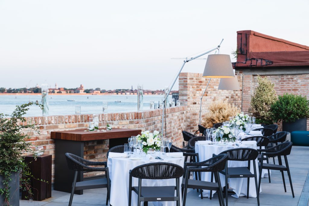 In questa foto tavolini allestiti per un matrimonio sulla terrazza del nuovissimo NH Collection Venezia Murano Villa