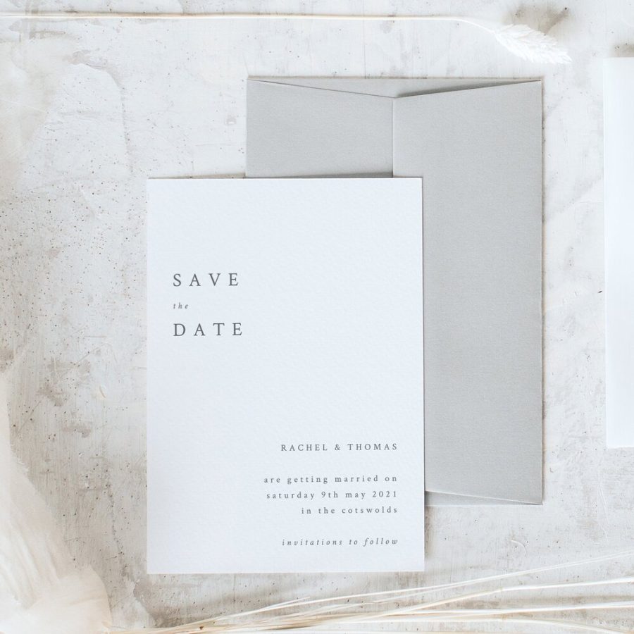 In questa foto un save the date per matrimonio con biglietto bianco e busta colore grigio perla