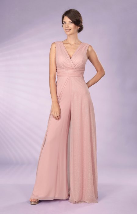 Una modella indossa una Jumpsuit di Musani Couture. Colore rosa tenue. Il corpetto ha lo scollo a incrocio ed è fasciato a vita. I pantaloni sono larghi.  