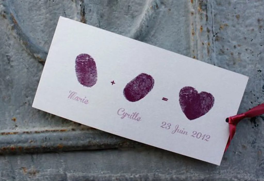 In questa foto un save the date con le impronte digitali degli sposi e la data delle nozze scritte in viola