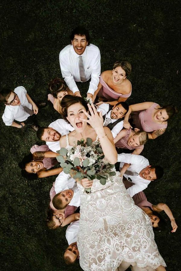 In questa foto scattata con un drone una sposa mostra la fede mentre viene lanciata in aria dai suoi amici inquadrati sotto