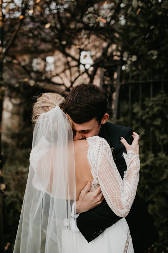 In questa foto uno sposo abbraccia la sposa ritratta di spalle, felici dopo il loro corso prematrimoniale