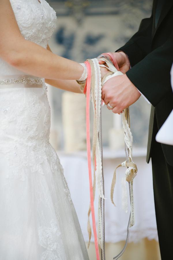 In questa foto il rito simbolico dell'Handfasting o delle mani legate con nastri di pizzo e di velluto nei colori rosa e beige