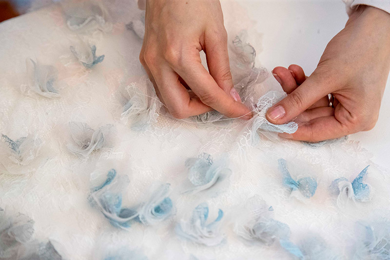 Un ricamo cucito a mano su un abito da sposa realizzato da Sofia Provera