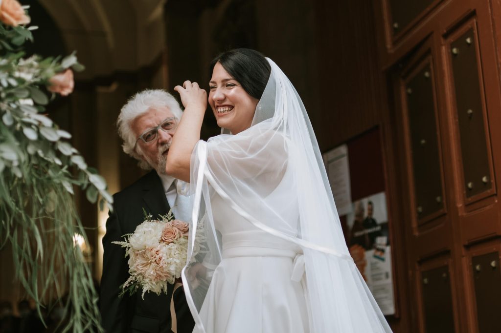 In questa foto una sposa si commuove prima di entrare in chiesa al braccio del papà