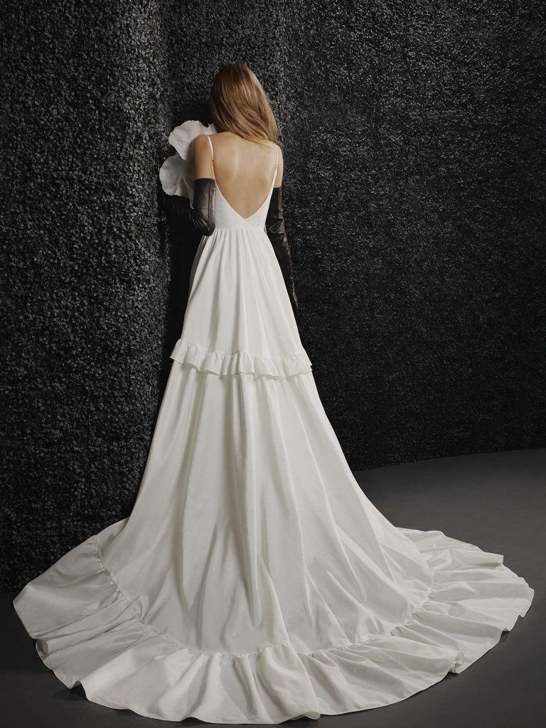 In questa foto una modella indossa un abito da sposa schiena scollata 2022 della collezione Vera Wang. Lo scollo è profondo a V.