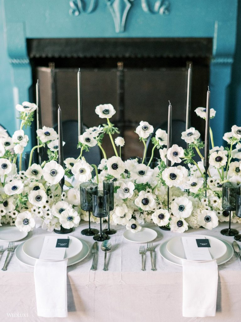 In questa foto il dettaglio di una tavola rettangolare decorata con anemoni bianchi e bicchieri neri 