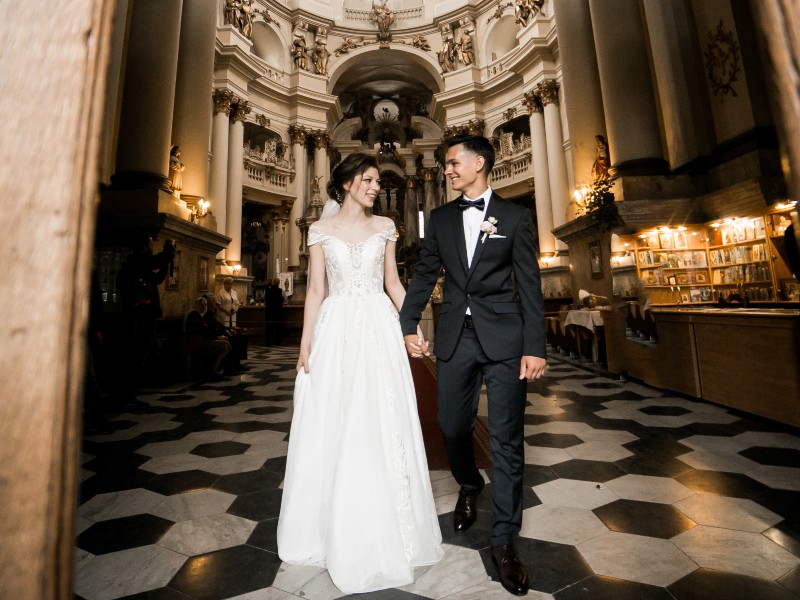 In questa foto due sposi sorridenti mentre escono da una chiesa dopo il loro rito del matrimonio