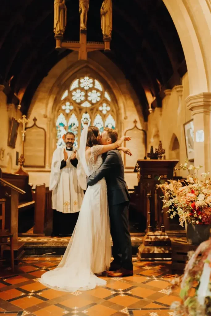 In questa foto due sposi si baciano alla fine del rito del matrimonio in chiesa