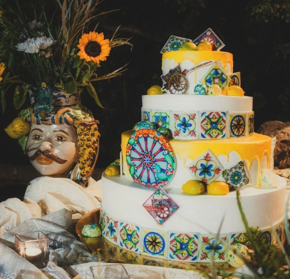 In questa foto una torta nuziale, il cui design è stato curato da Francesca Ternullo di Effecreazioni, con toni del giallo, decori in maiolica e riproduzioni di limoni e carretti siciliani