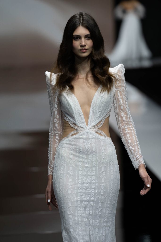 In questa foto la modella indossa un abito da sposa della collezione sposa Michela Ferriero 2023 con grandi spalline e profondo scollo.