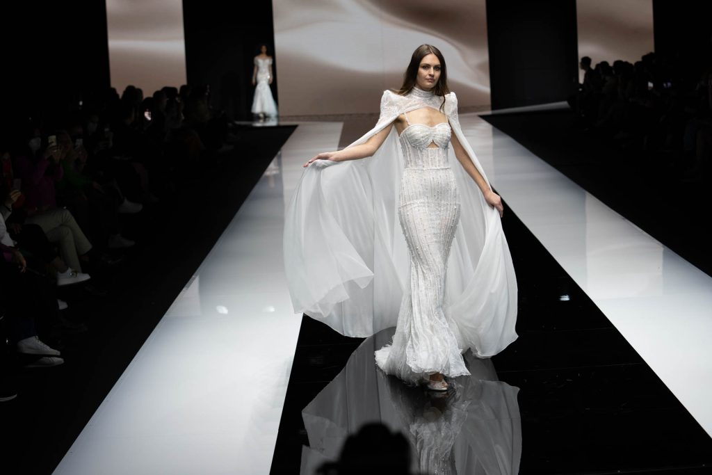 In questa foto la modella indossa un abito da sposa della collezione sposa Michela Ferriero 2023 con mantella bianca.