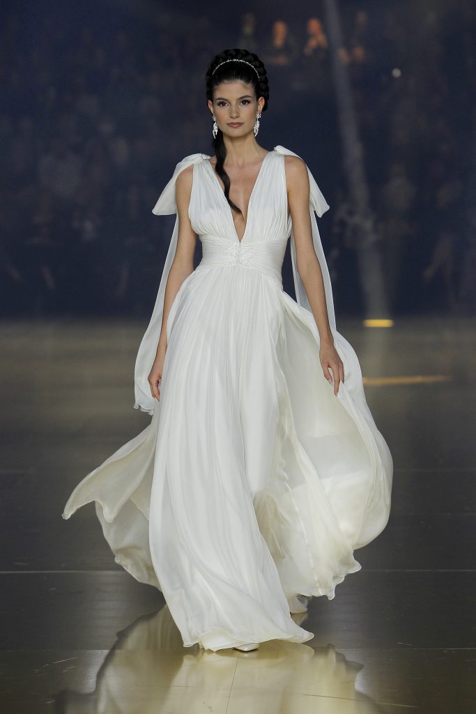 In questa foto una modella indossa un abito da sposa Atelier Pronovias 2023, visto sulla passerella della BBFW 2022