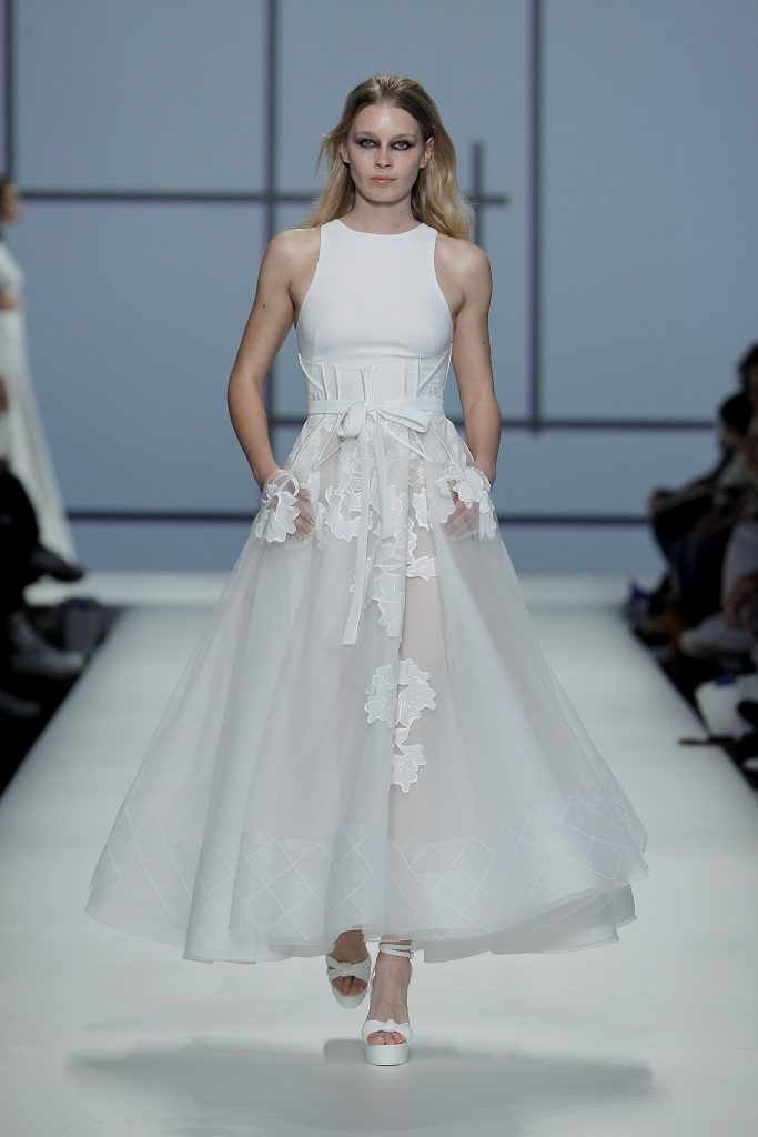 In questa foto una modella indossa un abito da sposa Rosa Clarà 2023, visto sulla passerella della BBFW 2022
