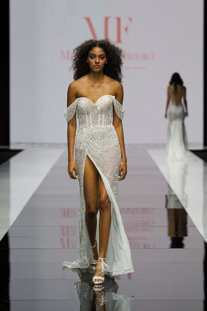 In questa foto la modella indossa un abito da sposa della collezione sposa Michela Ferriero 2023 con profondo spacco.
