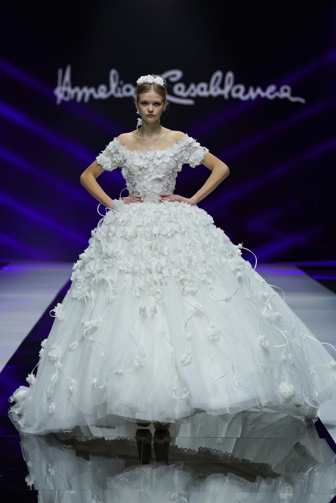 In questa foto la modella indossa un abito da sposa con gonna ampia di tulle e fiori Amelia casablanca 