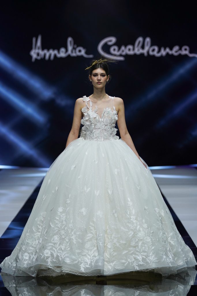 In questa foto la modella indossa un abito da sposa a principessa con gonna di tulle e fiori Amelia Casablanca 