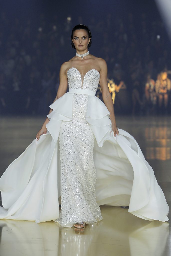 In questa foto la modella indossa un abito Atelier Pronovias 2023 con ampia coda.