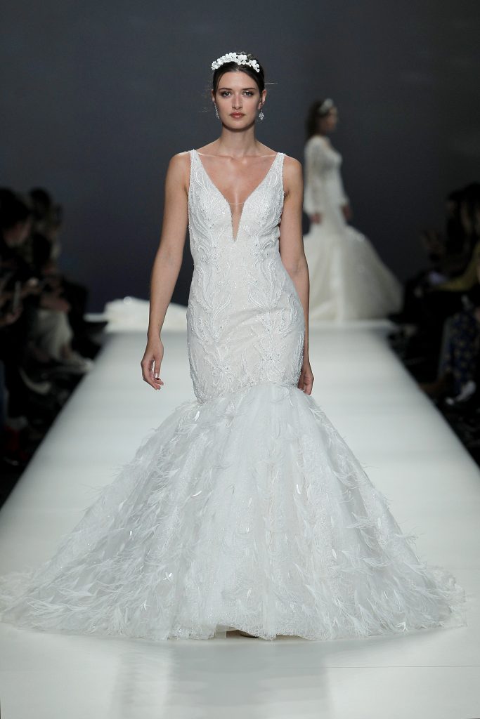 In questa foto la modella indossa un abito da sposa Demetrios a sirena con piume.