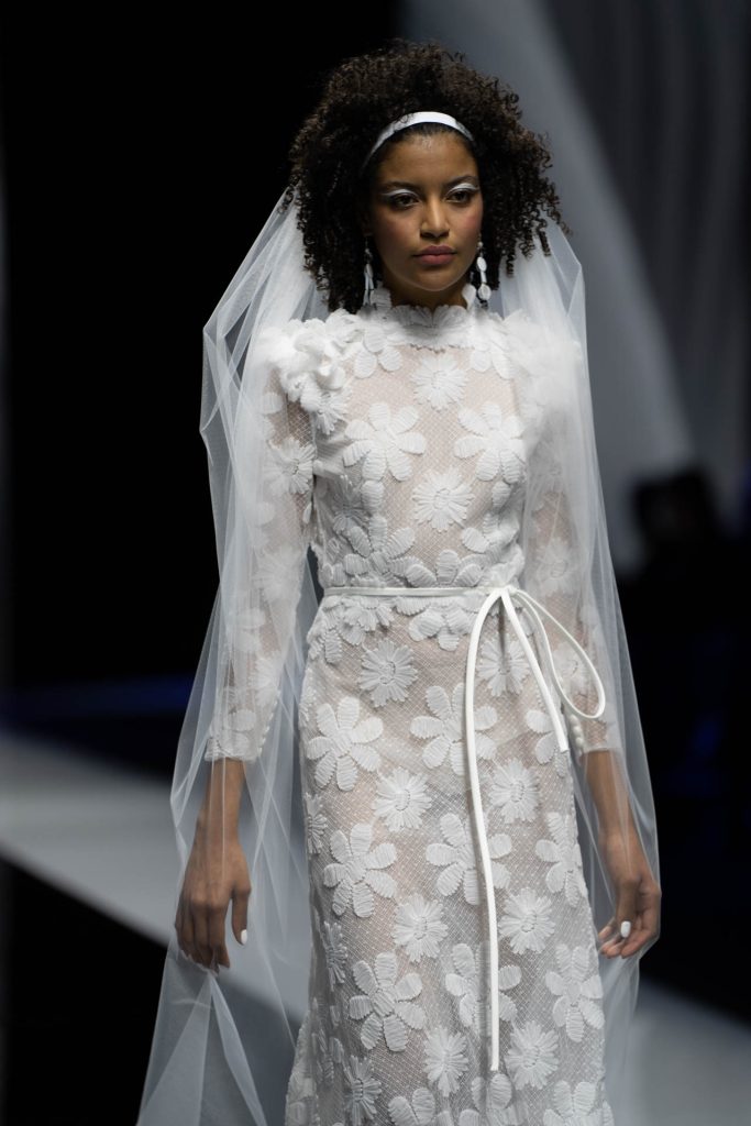 La modella indossa un abito con margherite della nuova collezione sposa Elisabetta Polignano 2023.