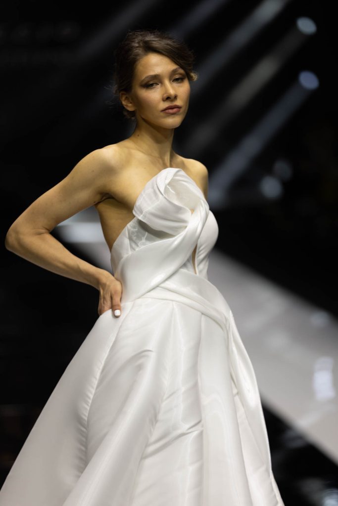 In questa foto la modella indossa un abito da sposa Enzo Miccio 2023 con dettaglio in organza.