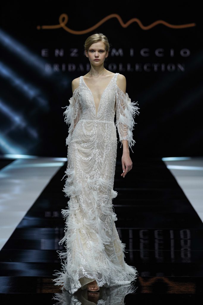 In questa foto la modella indossa un abito da sposa Enzo Miccio 2023 con piume.