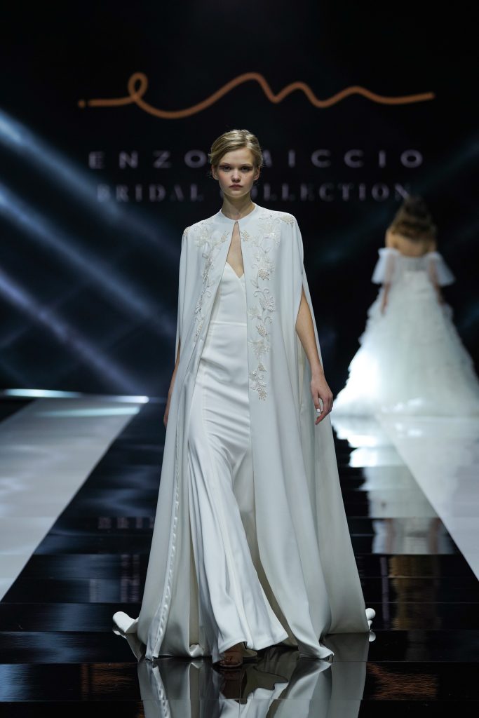 In questa foto la modella indossa un abito da sposa Enzo Miccio 2023 con mantella.