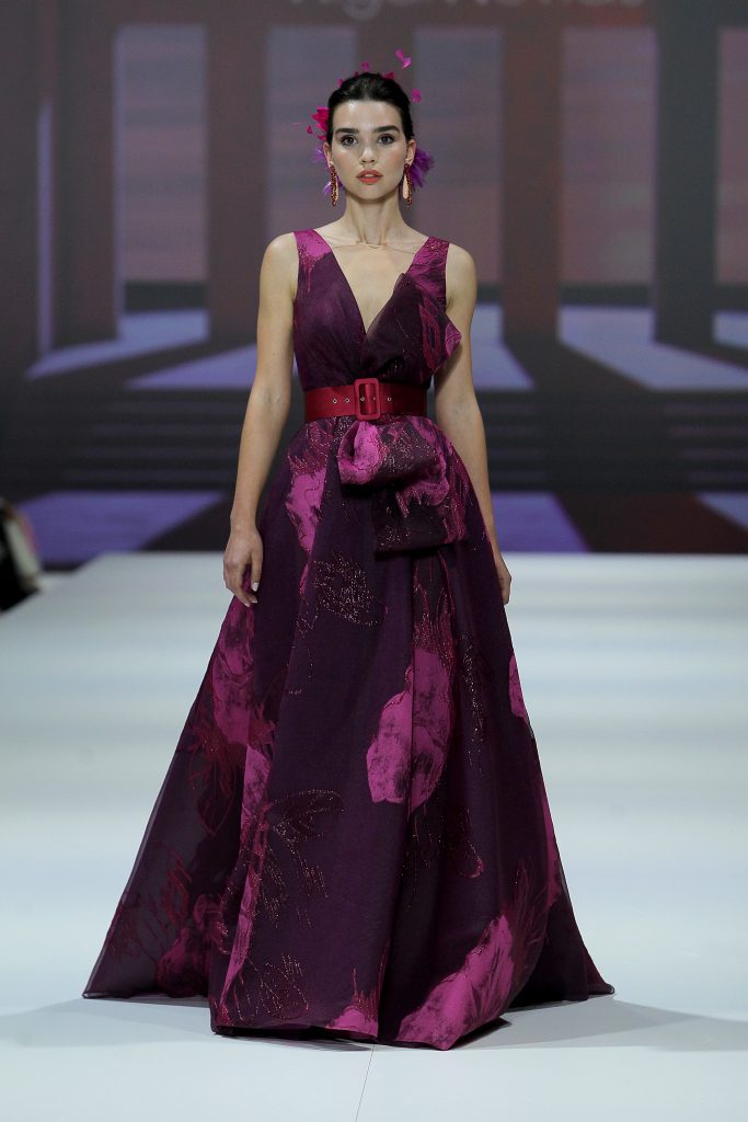 In questa foto la modella indossa un abito da cerimonia Higar Novias 2023 con scollo a V sui toni del viola.