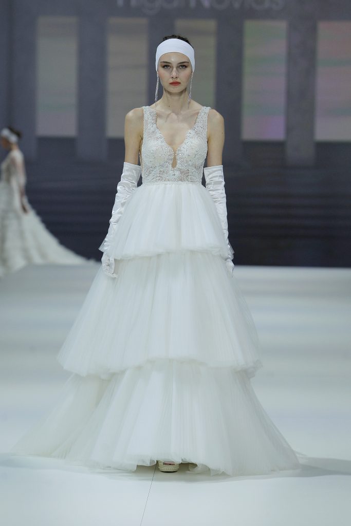 In questa foto la modella indossa un abito Higar Novias 2023 con gonna di tulle a balze.