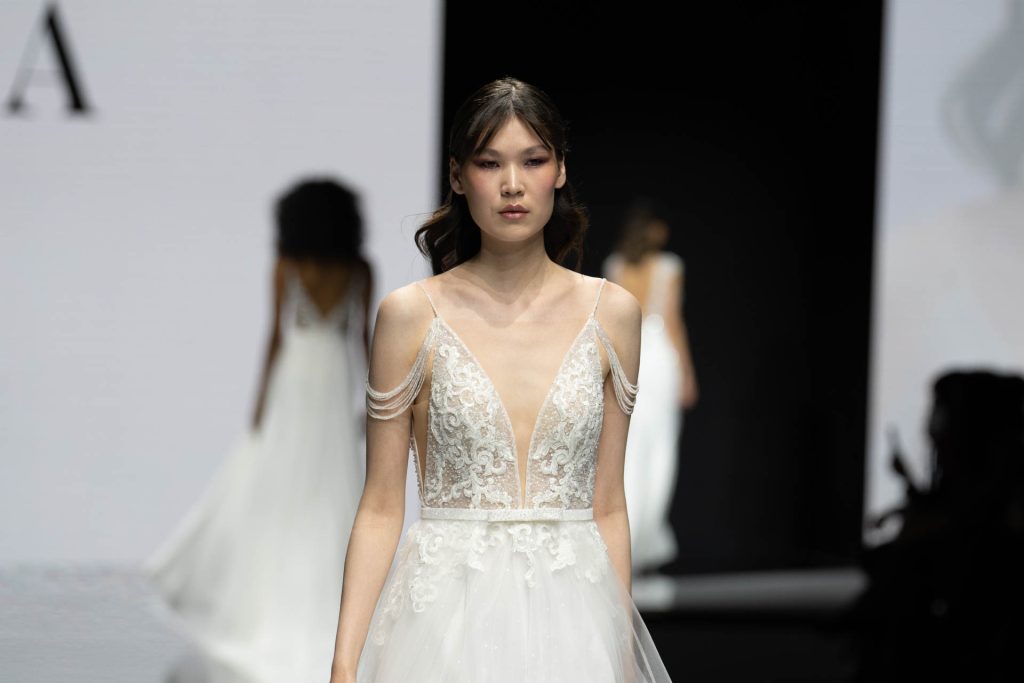 In questa foto la modella indossa un abito da sposa Maison Signore 2023  con profondo scollo a V.