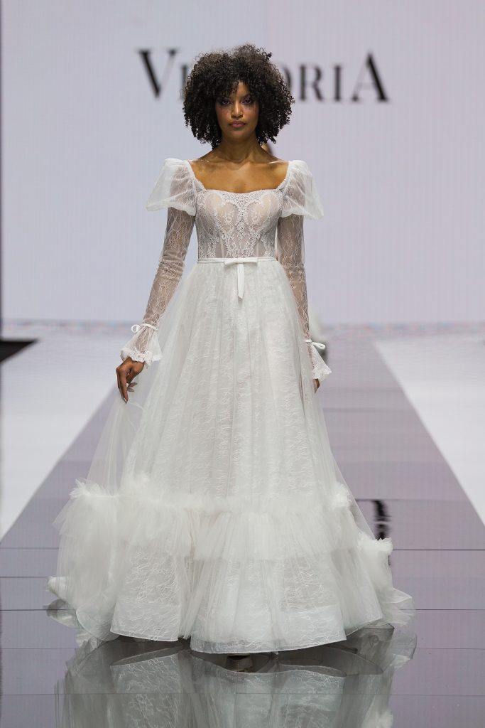 In questa foto la modella indossa un abito da sposa Maison Signore 2023 con delle balze finali.