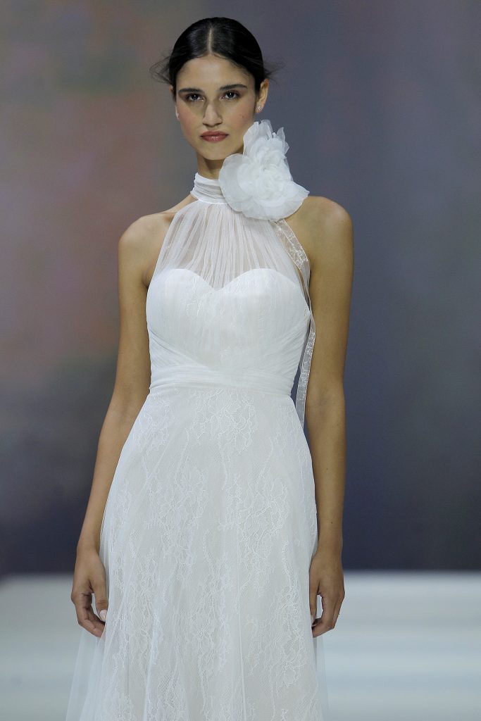 In questa immagine la modella indossa un abito da sposa Marchesa for Pronovias 2023 con maxi fiore.