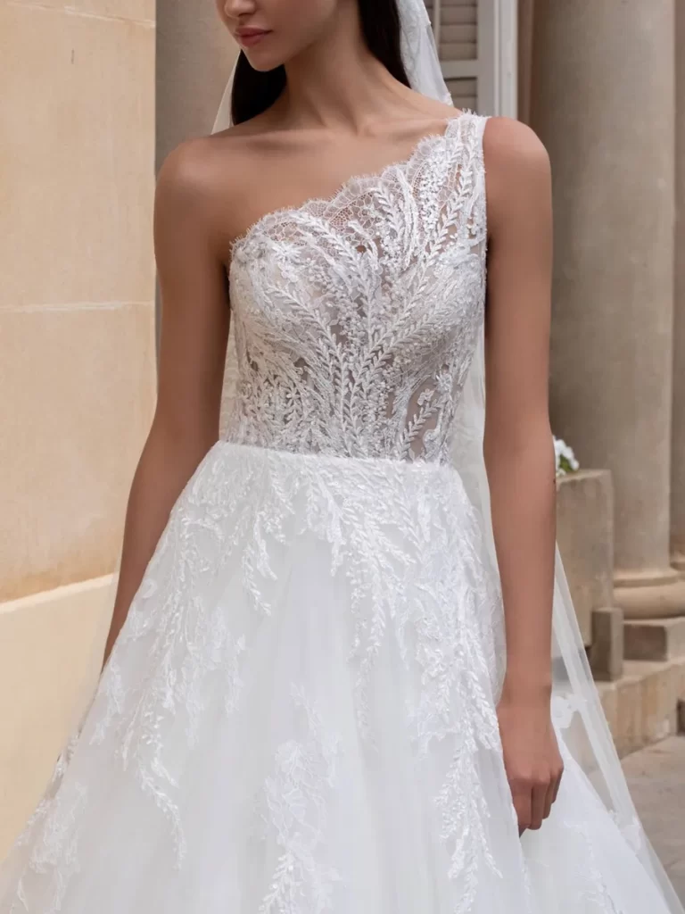 In questa foto una modella indossa un abito da sposa monospalla 2022 della collezione Pronovias.
