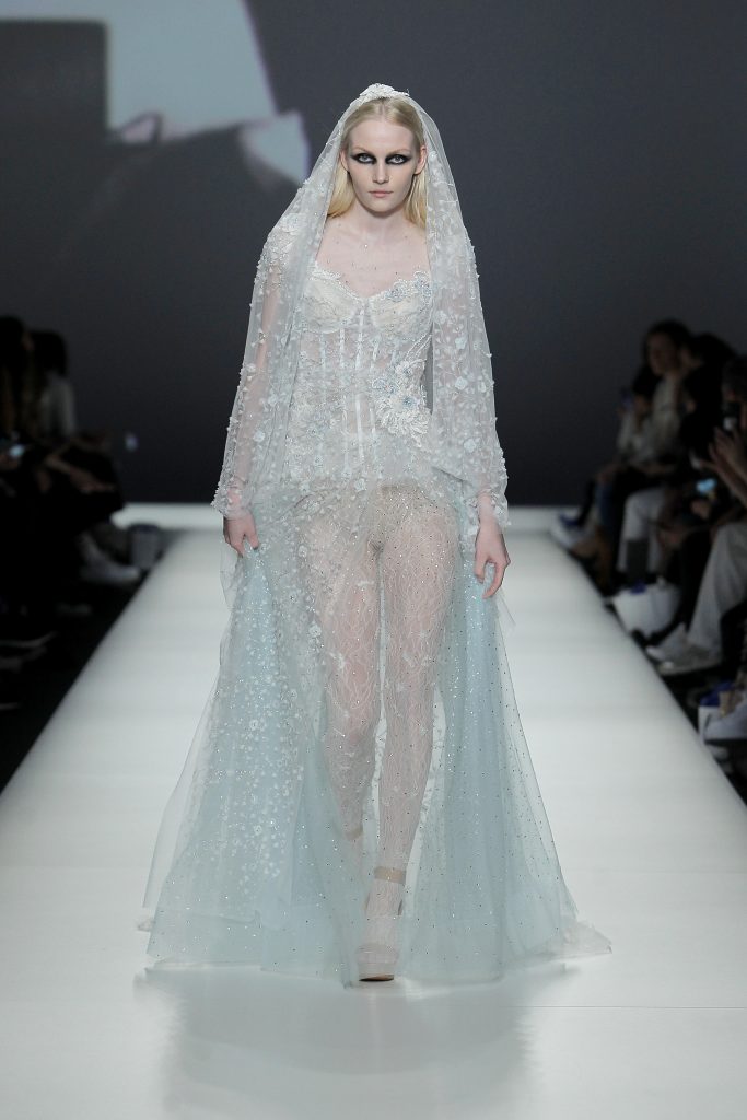 In questa foto la modella indossa un abito da sposa Yolancris con fiori color celeste e bianco.