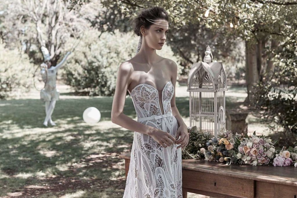 In questa foto una modella posa con un abito senza spalline e porta un'acconciatura da sposa con capelli raccolti