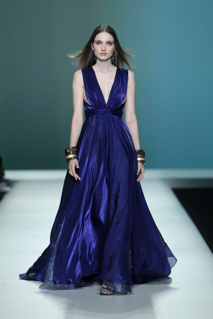 In questa foto la modella indossa un abito Carlo Pignatelli 2023 blu con scollo a V.