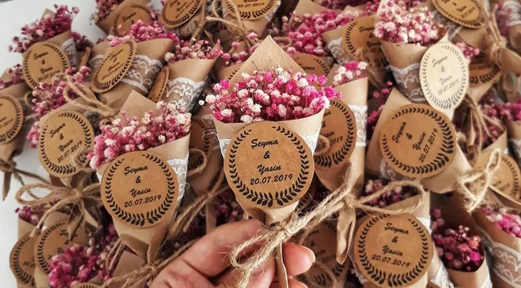 In questa foto bomboniere per matrimonio calamita a forma di piccoli bouquet colore rosa e fucsia