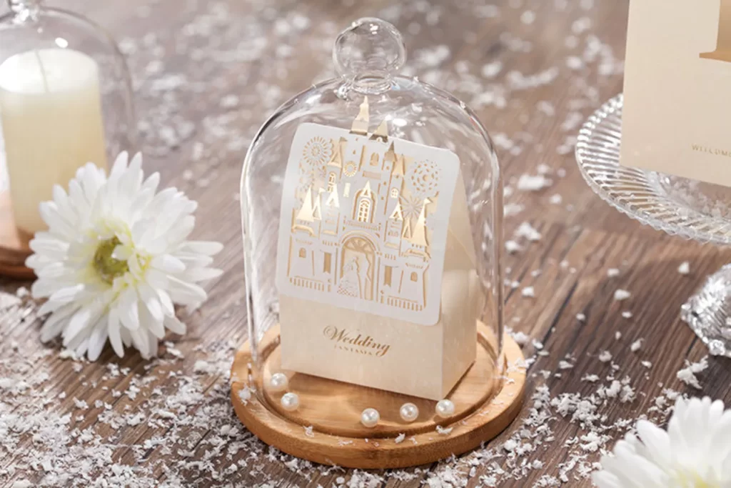 In questa foto una bomboniera per matrimonio a tema Disney a forma di ampolla con all'interno un sacchettino di cartoncino colore bianco con il disegno di un castello in colore oro