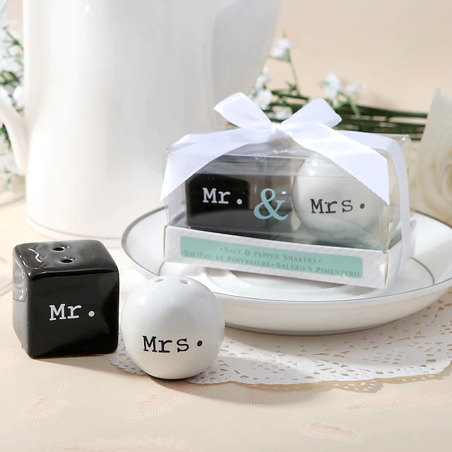 In questa foto una bomboniera di nozze con porta sale e porta pepe nei colori bianco e nero con le scritte Mr. e Mrs.
