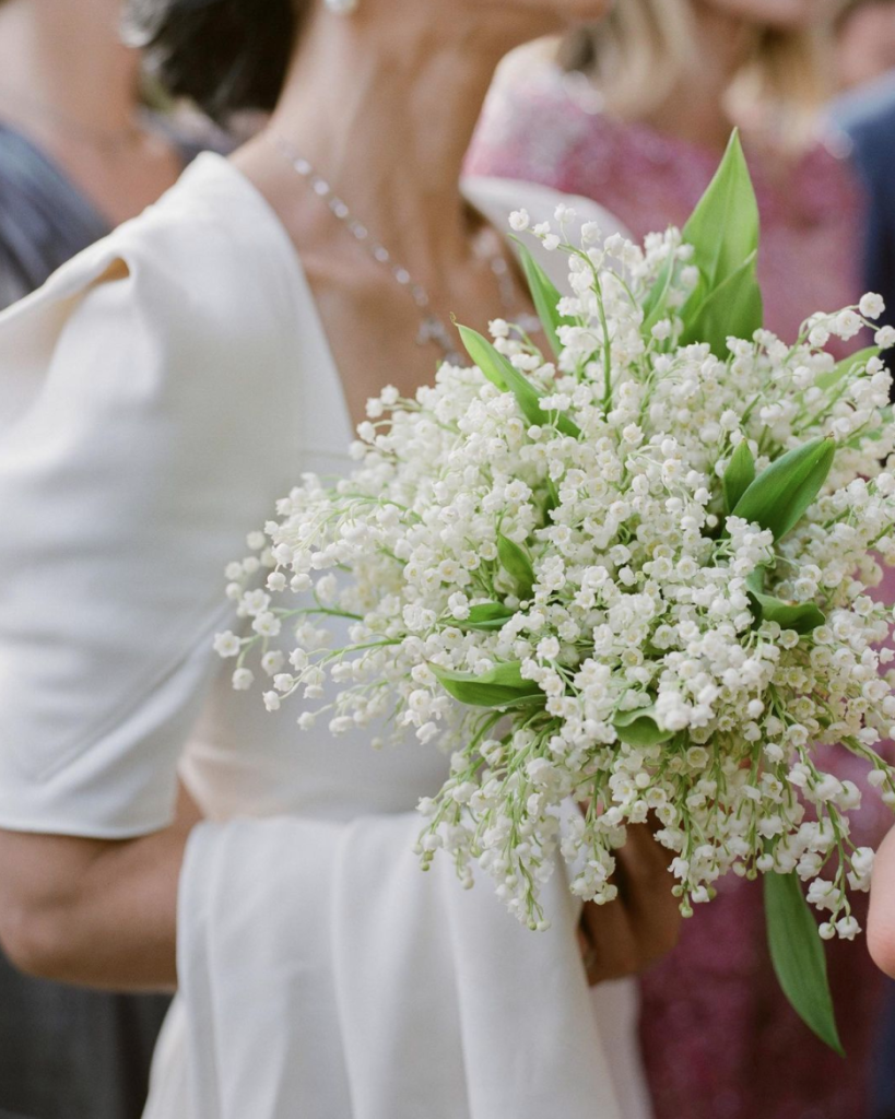 In questa foto una sposa tiene tra le mani un bouquet di nebbiolina bianca