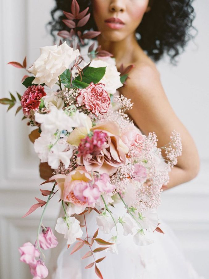 In questa foto una modella posa con un bouquet a cascata con fiori bianchi e rosa