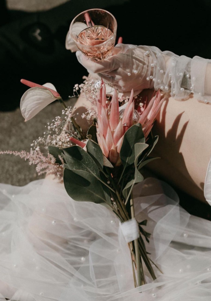 In questa foto un piccolo bouquet da sposa per matrimonio civile con fiori tropicali, anthurium e astilbe rosa chiusi da foglie di alloro