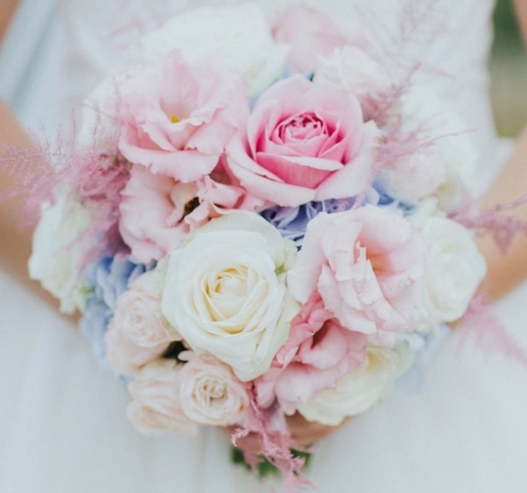 In questa foto un bouquet rotondo con rose rosa e bianche e ortensie celesti