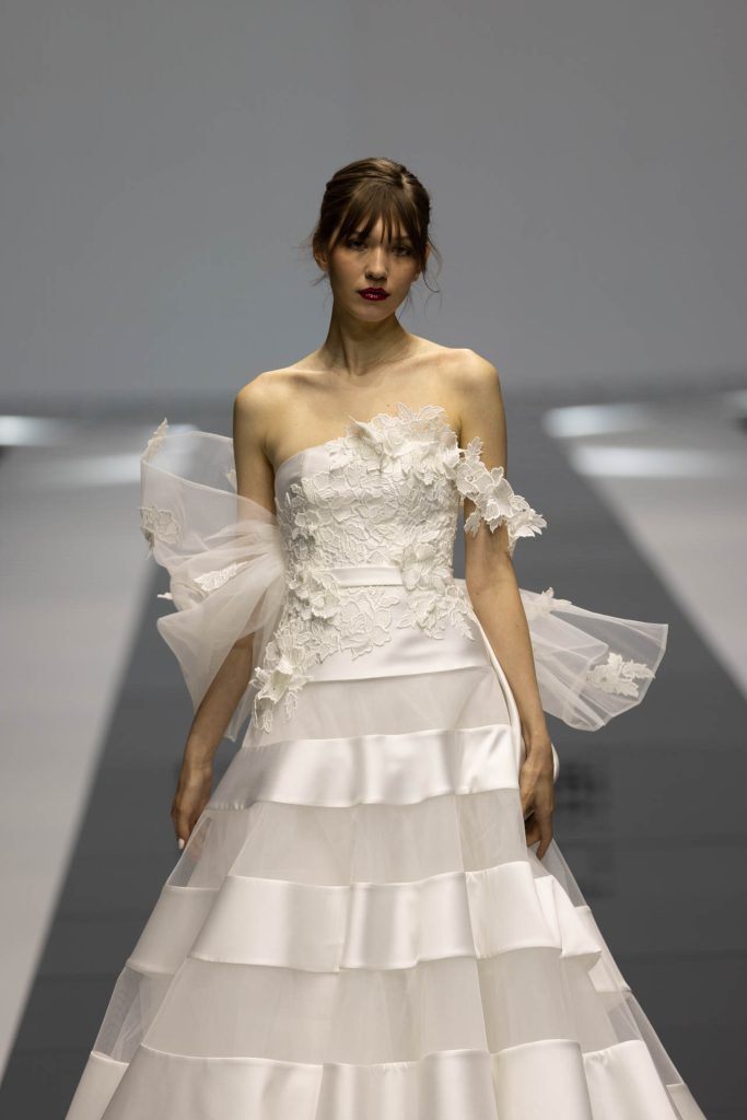 In questa foto la modella indossa un abito della collezione sposa Giuseppe Papini 2023 con gonna a righe.