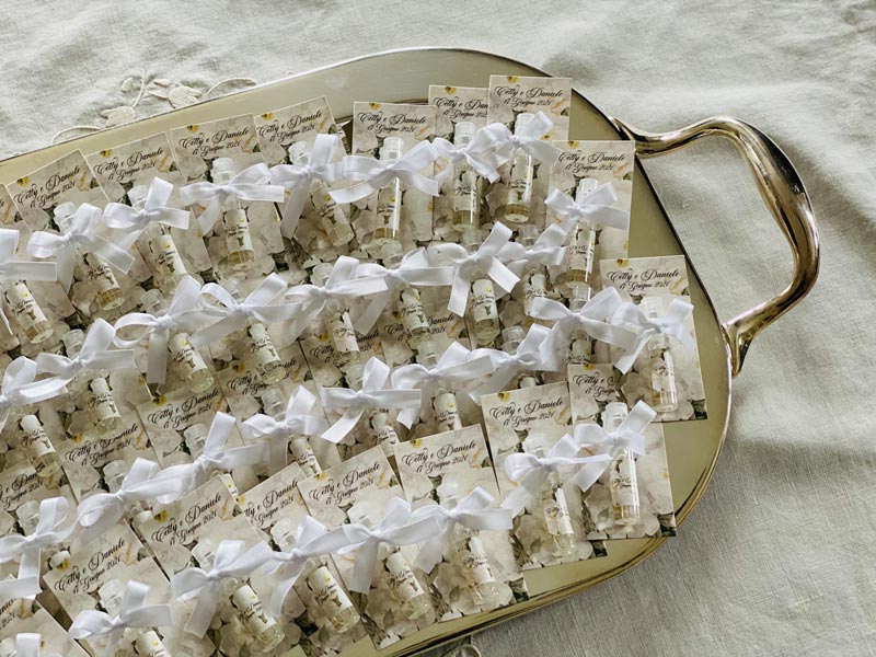 In questa foto tantissimi flaconcini di profumo personalizzato per matrimonio su un vassoio, pronti ad essere regalati agli ospiti delle nozze